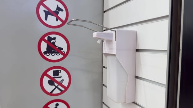 Sanitizer on wall at entrance. Antiseptic dispenser to protect hands from bacteria and germs. Disinfector for safety of people after covid. Life after pandemic with prevention of cases of illness