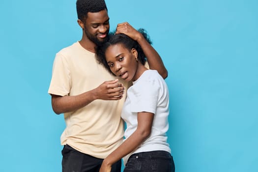 A joyful couple expressing affection on a blue backdrop, reflecting love and togetherness Ideal for themes of relationships, happiness, and emotional connection
