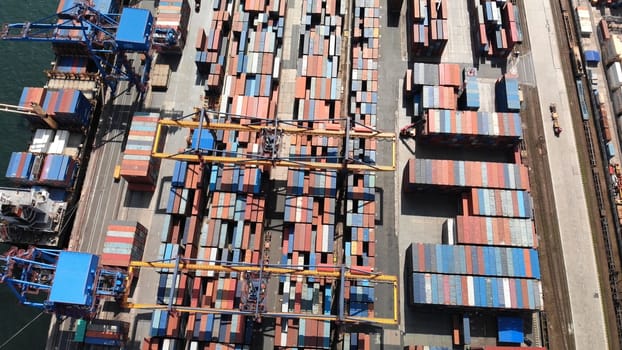 Aerial view of a container ship being loaded at a busy port, showcasing global trade and logistics