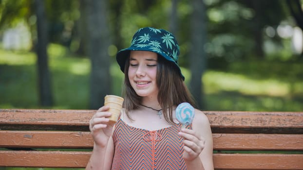 Teenage girl relaxing on park bench, savoring colorful ice cream and lollipop during sunny afternoon