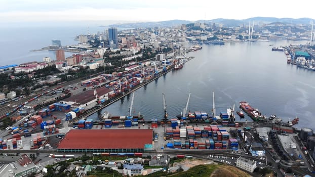 Industrial cargo cranes loading colorful containers onto freight ships at vladivostok seaport, key maritime trade gateway in russian far east