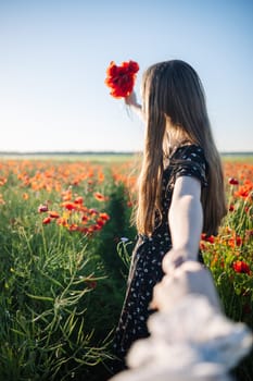 Loving couple strolling hand in hand through blooming poppy field during golden sunset moment