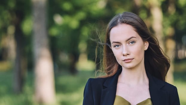 Professional businesswoman standing confidently in park setting, embodying career success and corporate leadership