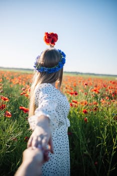 Romantic couple enjoying a summer day while holding hands in a stunning poppy field, surrounded by vibrant flowers and nature's beauty