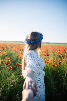Romantic couple walking hand in hand through blooming poppy field, sharing intimate moment during sunny summer afternoon