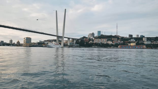 Golden bridge spanning zolotoy rog bay, highlighting vladivostok's urban landscape against scenic waterfront background