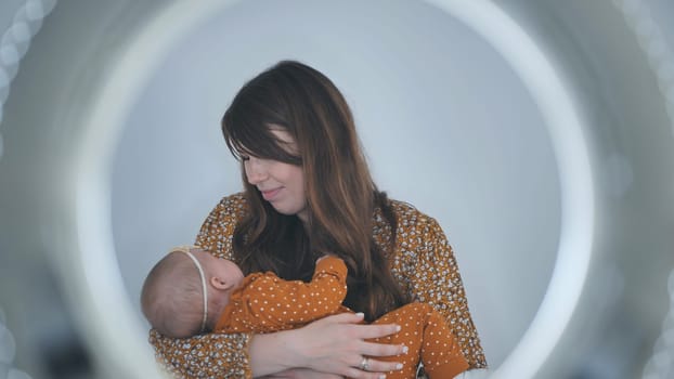 Soft circular lighting highlighting maternal warmth, mother gently holding sleeping newborn daughter close to her heart