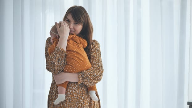 Young mother cradling her infant daughter, creating a tender moment of love and connection in a softly lit home setting