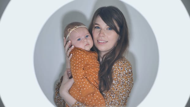 Radiant mother gently cradling newborn daughter, soft golden light surrounding intimate maternal bond, tender connection glowing with pure affection