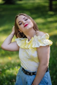 Fashionable young woman adjusting her hair while posing in a park, wearing a stylish summer outfit