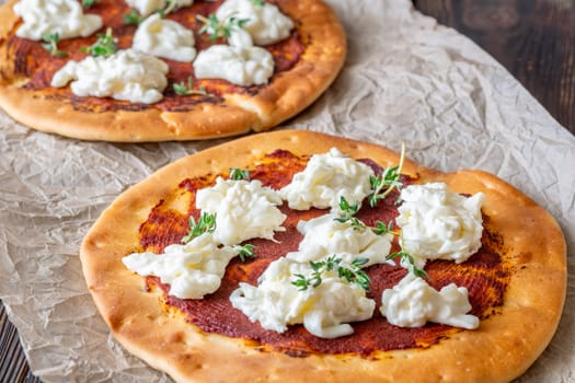 Golden crusts cradle warm stracciatella and sauce, accented with sprigs of thyme