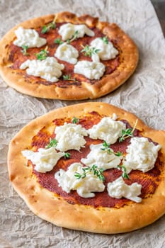 Golden crusts cradle warm stracciatella and sauce, accented with sprigs of thyme