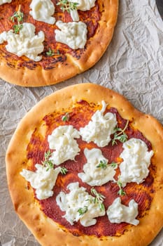 Golden crusts cradle warm stracciatella and sauce, accented with sprigs of thyme