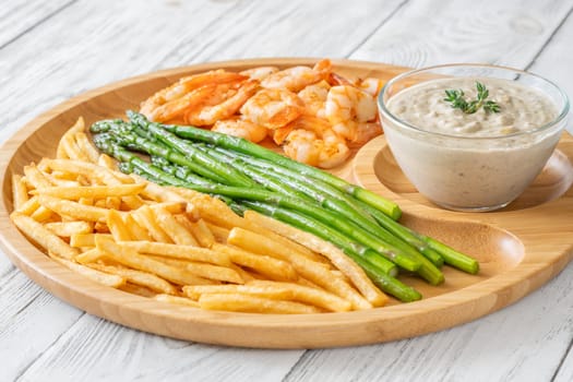 Crispy shrimp and fries balance soft asparagus and creamy sauce with thyme