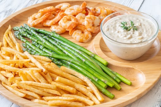 Crispy shrimp and fries balance soft asparagus and creamy sauce with thyme
