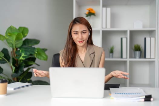 A professional woman participates in an online discussion, expressing ideas and engaging with her team while working from home.