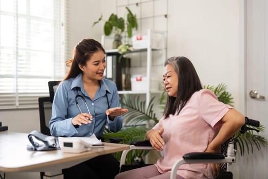 A caring nurse assists an elderly woman in a medical consultation, offering health advice in a pleasant and professional environment focused on patient well-being.