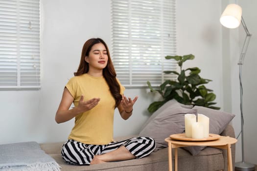 A woman sits peacefully, surrounded by candles, enhancing her meditation experience and cultivating a sense of calm.
