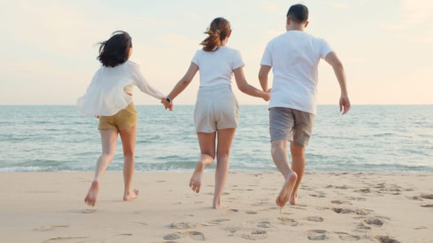 Happy friends holding hands running enjoy life funny and freedom on sand at beach together to sea in holiday vacation time at sunset, Young Asian group woman and man in summer travel, people lifestyle
