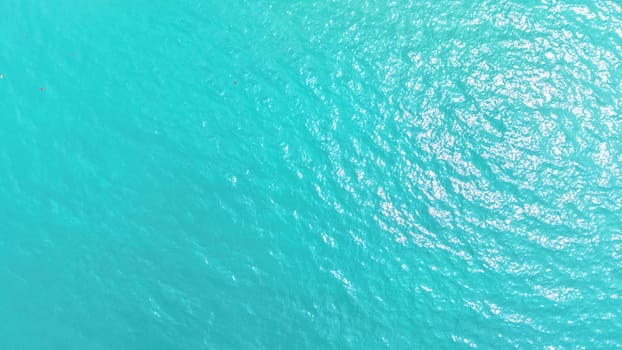 Stunning view of a vibrant turquoise ocean surface with gentle ripples, capturing the serene and refreshing essence of the sea. Perfect for backgrounds or nature themed designs