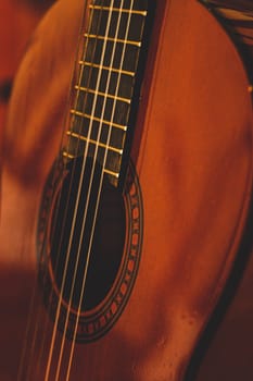 Detail of a wooden classical guitar showing the sound hole, strings and part of the fretboard under soft warm light. Perfect for concepts of music, creativity, traditional instruments, and cultural expression.