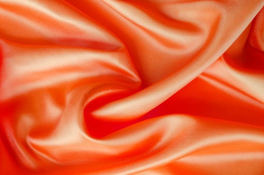 Radiant satin fabric in light red color, showcasing fluid motion and shine. Suitable for design and wallpaper background.