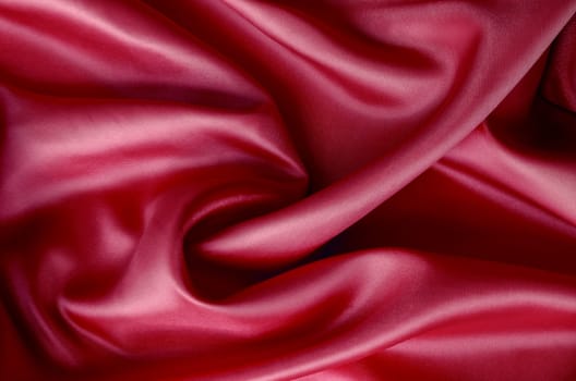 Dark red silk with soft curves and vibrant reflective surface. Suitable for design and wallpaper background.