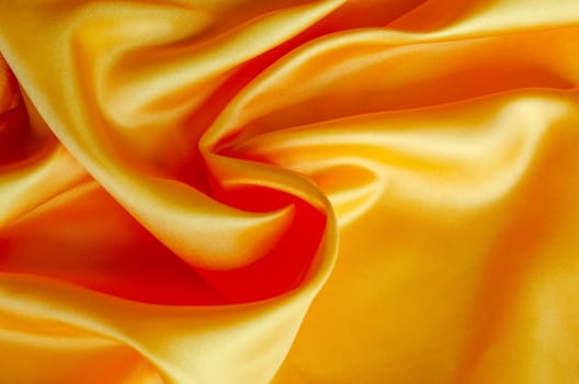 Golden silk showing detailed texture and radiant light reflections. Suitable for design and wallpaper background.