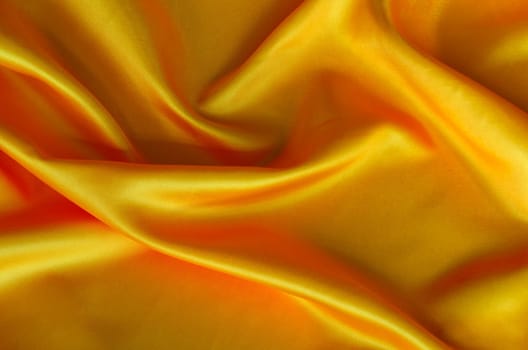 Polished golden silk cloth with silky sheen and beautiful natural draping. Suitable for design and wallpaper background.