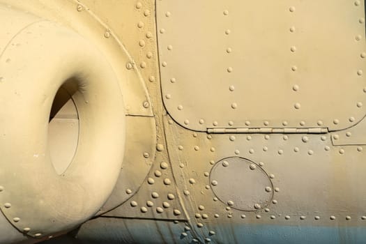 Fuselage of a military aircraft showcases intricate details and textures, highlighting rivets, access panels, and structural elements.