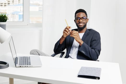Confident businessman at desk holding pencil, preparing for a productive day in a stylish, modern office environment.