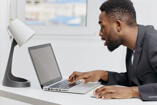 Business professional working late at night in a modern office with laptop, desk lamp, and stacks of paperwork.