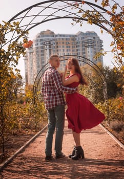 Happy young couple in love spending time together in autumn park hugging. Romantic couple enjoying moments of happiness in city park. Love and tenderness, dating, romance. Lifestyle concept