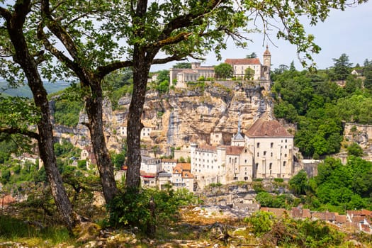 Rocamadour, the medieval village perched on a steep cliff over the Alzou valley, attracts numerous pilgrims and tourists in France, vertical view