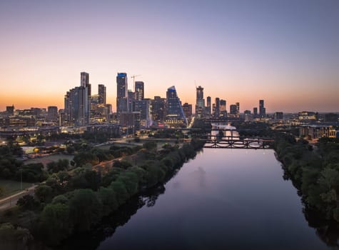 Brilliant orange and red sky behind the illuminated city skyline of Austin Texas before sunrise dawn