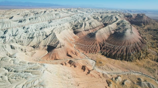 Aerial view of the colorful chalk mountains in the altyn-emel national park in kazakhstan, showcasing unique rock formations and canyons under a clear blue sky