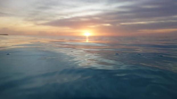 The golden hues of a breathtaking sunset paint the sky, casting a warm glow upon the tranquil surface of the ocean, creating a serene and picturesque scene