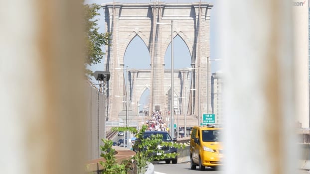 New York City, United States - 3 Sept 2023: Cars on Brooklyn Bridge from Manhattan downtown to Dumbo. Financial district skyline cityscape. Road traffic, people walking and USA architecture.
