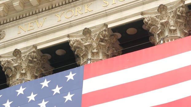 New York City, United States - 9 Sept 2023: Lower Manhattan Downtown Financial District urban architecture. Huge big American flag. Wall street Stock Exchange building, USA Stock Market trading.