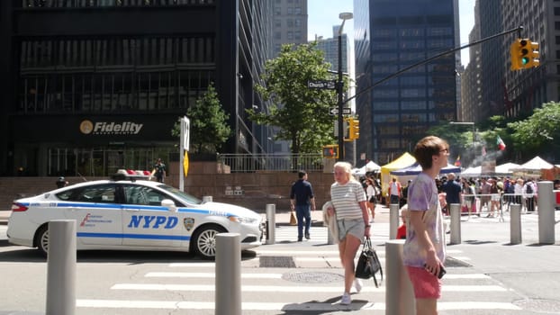 New York City, United States - 31 Aug 2023: Police patrol car, USA NYPD 911 vehicle on Manhattan Downtown Church street, Oculus. American cop auto. Urban road traffic, people crossing on zebra, market