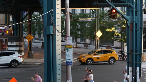 New York City, United States - 31 Aug 2023 Elevated subway above street. Metropolitan bridge over road, Queens. Long Island metro line, Court Square. Cars under metallic railway track. Yellow taxi cab