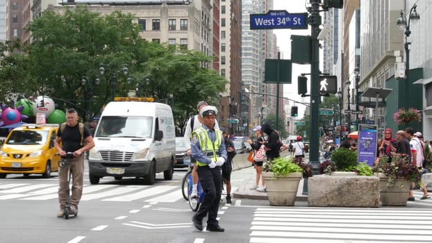 New York City, United States - 29 Aug 2023: Manhattan Midtown 34 street. Herald Square, Broadway, Sixth 6 Americas avenue, USA. People, zebra crosswalk. Road traffic Control Police guard, NYPD flagger