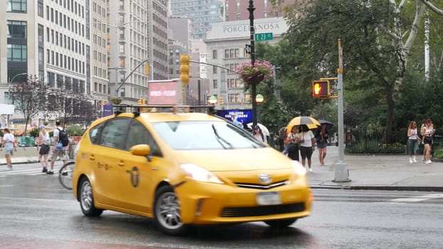 New York City, United States - 8 Sept 2023: Manhattan Midtown Broadway, 23 street, 5 avenue crossroad intersection. Madison Square Park by Flatiron Building, USA. People, subway and yellow taxi. Rain.