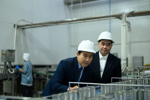 Two factory executives discussing operations inside a food manufacturing facility.