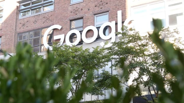 New York City, United States - 1 Sept 2023: Manhattan Midtown street or avenue. Urban red brick architecture USA. Google logo, logotype sign. NYC headquarters office near Chelsea Market and High Line.