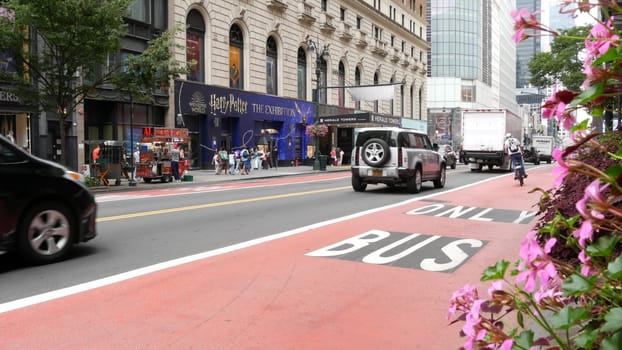 New York City, United States - 29 Aug 2023: Manhattan Midtown 34 street, near Herald Square, Broadway, 6 avenue. Urban road car traffic. Red bus lane for USA public transport. Yellow taxi cab, people.