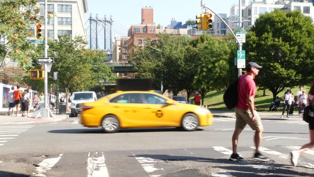 New York City, United States - 7 Sept 2023: Manhattan Bridge, Brooklyn Dumbo. Cars on road, traffic on Washington street crossroad. NYC yellow taxi cab. People walking, pedestrians on zebra crosswalk.