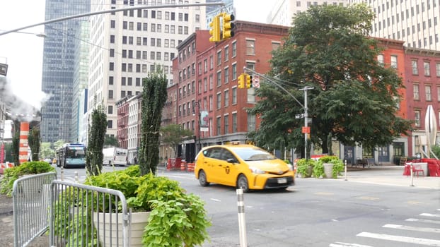 New York City, United States - 9 Sept 2023: Manhattan Downtown Financial District Water street crossroad intersection. USA. Urban road car traffic. Yellow taxi, people. Hot smoke stack, steam pipe.