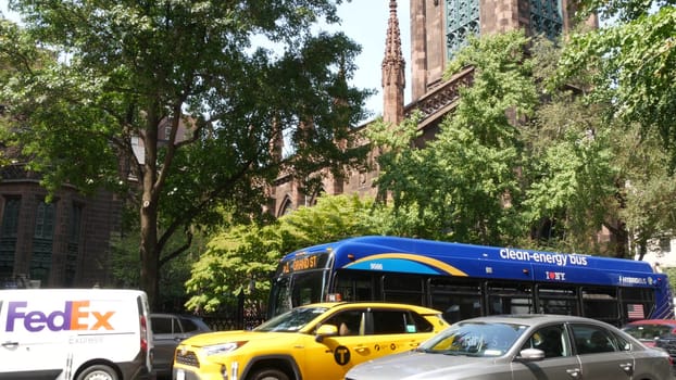 New York City, United States - 8 Sept 2023: Manhattan Greenwich Village street, 5th Fifth 5 avenue. American urban road car traffic. Yellow taxi cab, USA. Fedex car near The First Presbyterian Church.