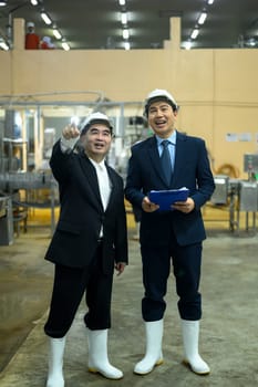 Two factory executives discussing operations inside a food manufacturing facility.